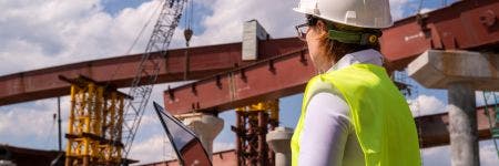 Female engineer overseeing the construction of a steel bridge