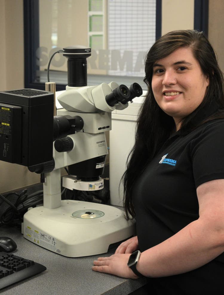 Quality assurance technician using the Olympus SZX10 industrial microscope to control the quality of the batch of membrane building envelope and roofing products produced in a SOPREMA manufacturing facility