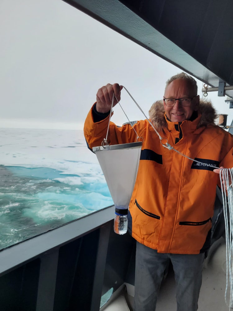 Jan van Ijken holds a net to collect plankton.