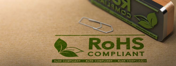 3D illustration of a rubber stamp with the text RoHS Compliant stamped on paper background.