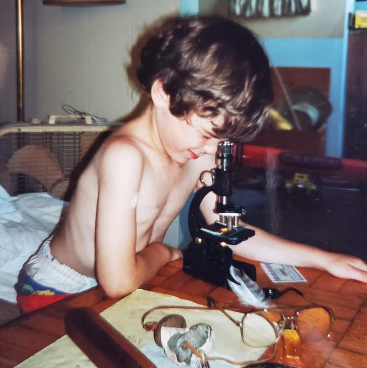 Olympus global image of the year (IOTY) 2020 contest winner for the Americas region, Justin Zoll, with a microscope he had when he was a child