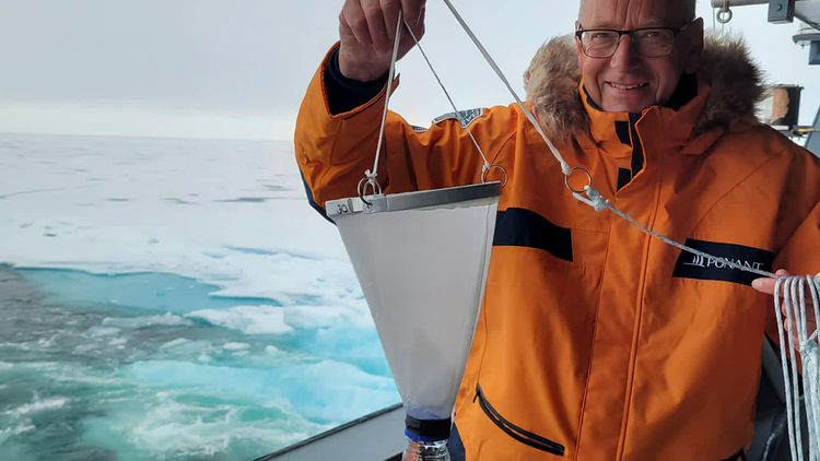 Jan van Ijken holds a net to collect plankton.
