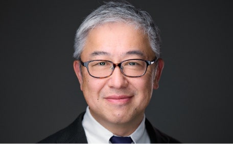 A person wearing glasses and a suit AI-generated content may be incorrect.