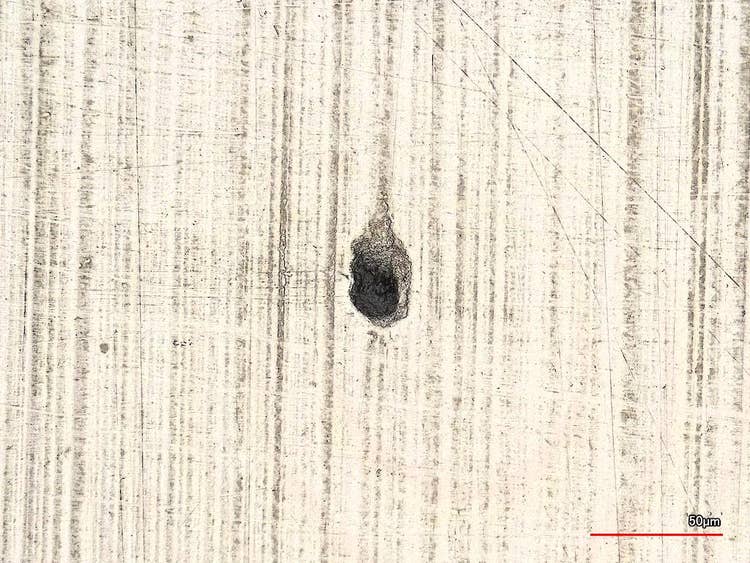 Picadura en una muestra de acero.