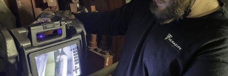 Operatore di Veracity Technology Solutions durante l'utilizzo di un videoscopio IPLEX NX Olympus IPLEX NX per l'esecuzione di un'ispezione visiva in remoto di una turbina a gas in un impianto di produzione energetica