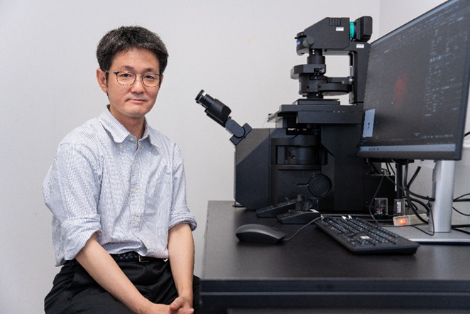 Kazuhiro Aoki next to the IXplore IX85 inverted microscope